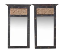 A pair of black painted and carved limed wood inset wall mirrors