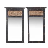 A pair of black painted and carved limed wood inset wall mirrors