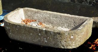 A rough hewn stone trough or basin