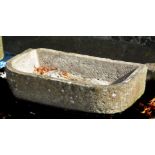 A rough hewn stone trough or basin