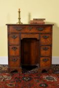 A Queen Anne walnut and feather banded kneehole desk