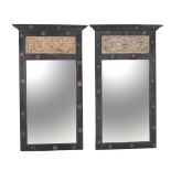 A pair of black painted and carved limed wood inset wall mirrors