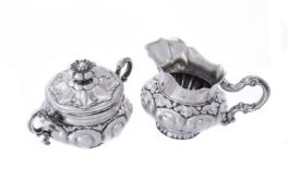 A silver cream jug and sugar basin and cover