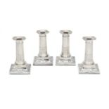 A set of four Edwardian silver short columnar candlesticks by The Goldsmiths & Silversmiths Co. Ltd