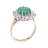 An emerald and diamond cluster ring