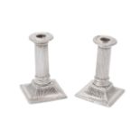 A pair of late Victorian silver small square candlesticks by Charles Stuart Harris