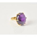 An oval cabochon amethyst ring