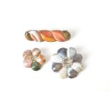 Three Scottish hardstone brooches:- a silver-coloured and agate brooch of shaped circular form set w