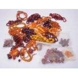 A large group of amber coloured and amber bead necklaces