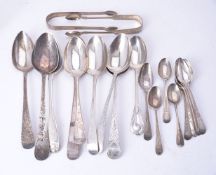 A collection of silver spoons and sugar tongs