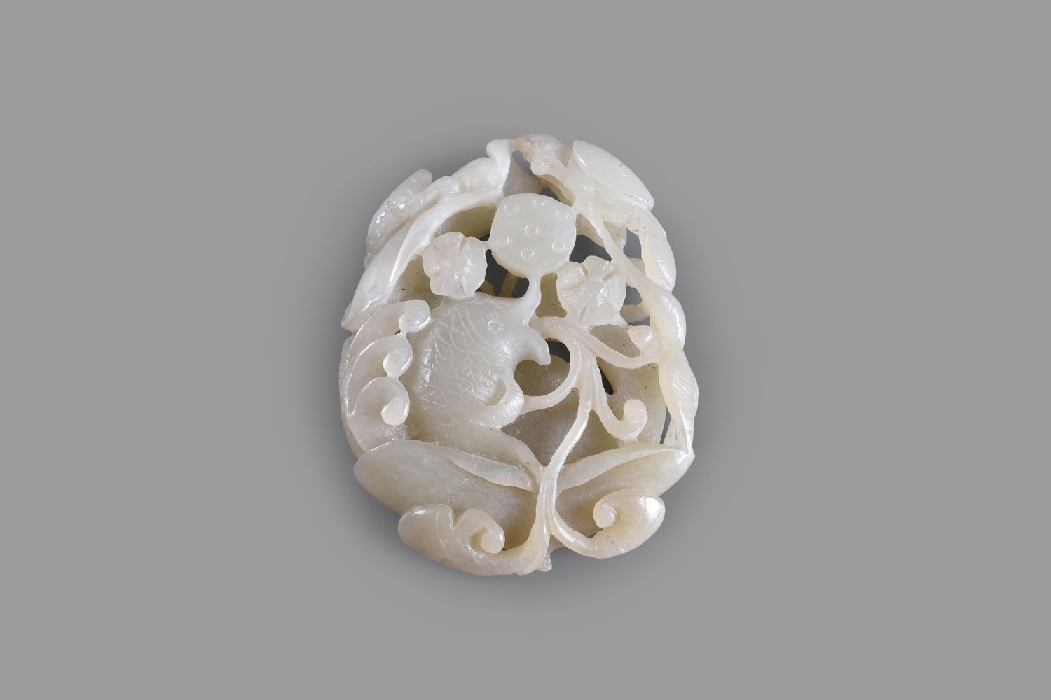 A Chinese celadon 'Fish and Lotus' jade carving