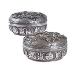 A pair of Chinese export silver 'longevity' circular boxes and covers