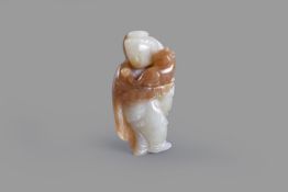 A Chinese celadon and russet jade 'Lady and cat' carving