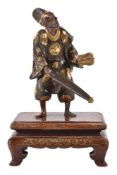 Miya-O Eisuke: A Japanese Parcel Gilt Figure of a Man standing dressed inelaborate robes and a court