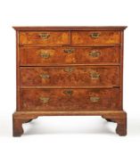 A Queen Anne burr walnut, figured walnut and feather banded chest of drawers, circa 1710