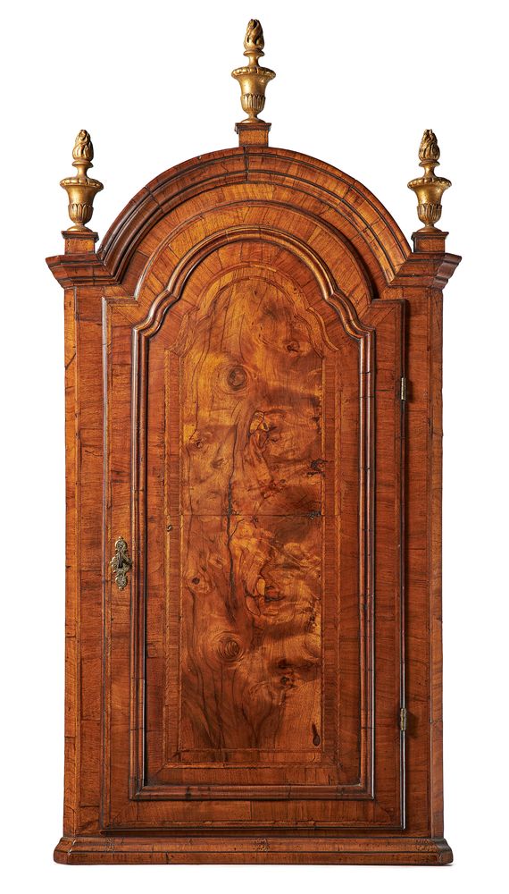 A Queen Anne walnut and feather banded domed top hanging corner cupboard, circa 1710