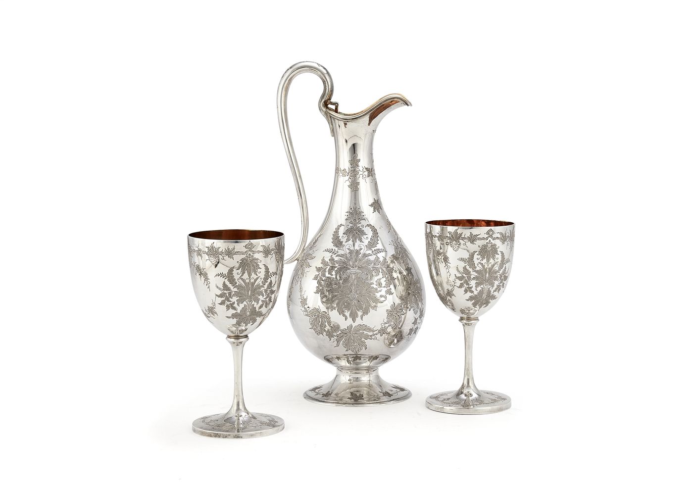 A Victorian silver claret jug and a pair of goblets by George Adams for Chawner & Co.