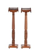 A pair of mahogany and brass strung torchere stands