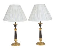 A pair of parcel gilt and lacquered metal table lamps in the manner of Charles X candlesticks