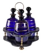 A Regency papier mâché tripartite decanter stand and three blue glass barrel-shaped decanters and st
