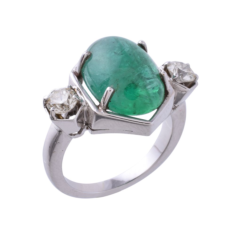 An emerald and diamond three stone ring