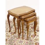 20th century figured walnut nest of three tables, shaped tops with inset glass, 60cm x 45cm,