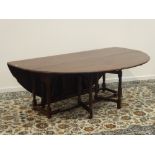 Large 17th century style medium oak wake table, oval drop leaf top, on turned supports,