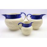 Three 19th century graduating relief moulded hunting scene jugs with blue glazed section,
