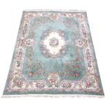 Large Chinese washed woollen rug carpet, pale mint ground, decorated with flowers and scrolls,