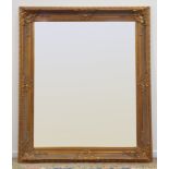 Large rectangular bevelled edge wall mirror in ornate swept gilt frame with shell and leaf
