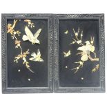 Pair of Japanese lacquer wall plaques decorated with applied birds and flowers in mother of pearl