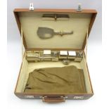 Ladies leather travelling toilet case with fitted with engine turned silver dressing table set,