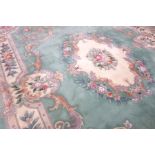 Large Chinese washed woollen rug carpet, pale mint ground, decorated with flowers and scrolls,