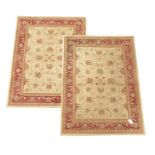 Pair Persian design beige and red ground rugs with stylised floral design,