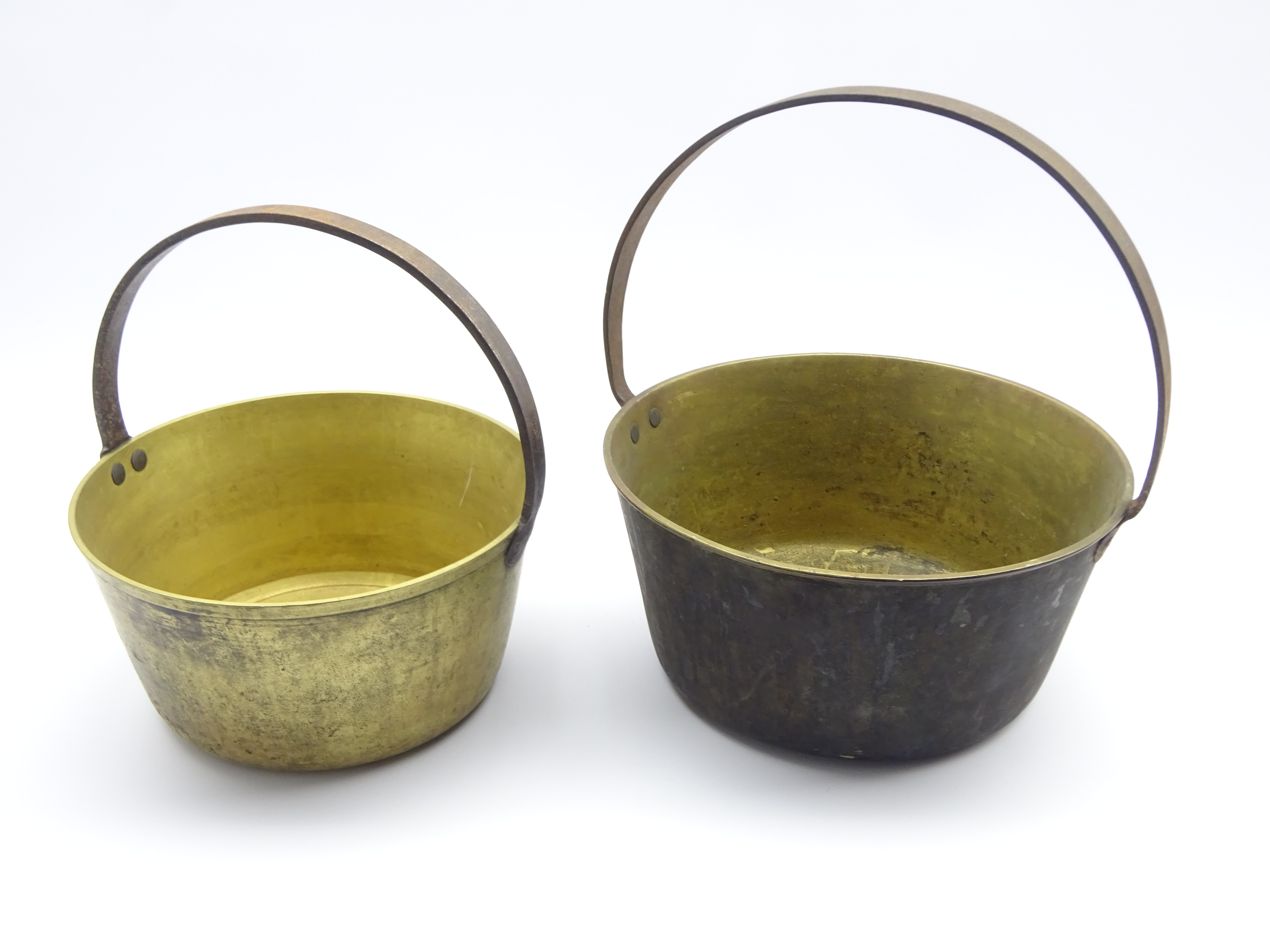 Two graduating brass jam pans,