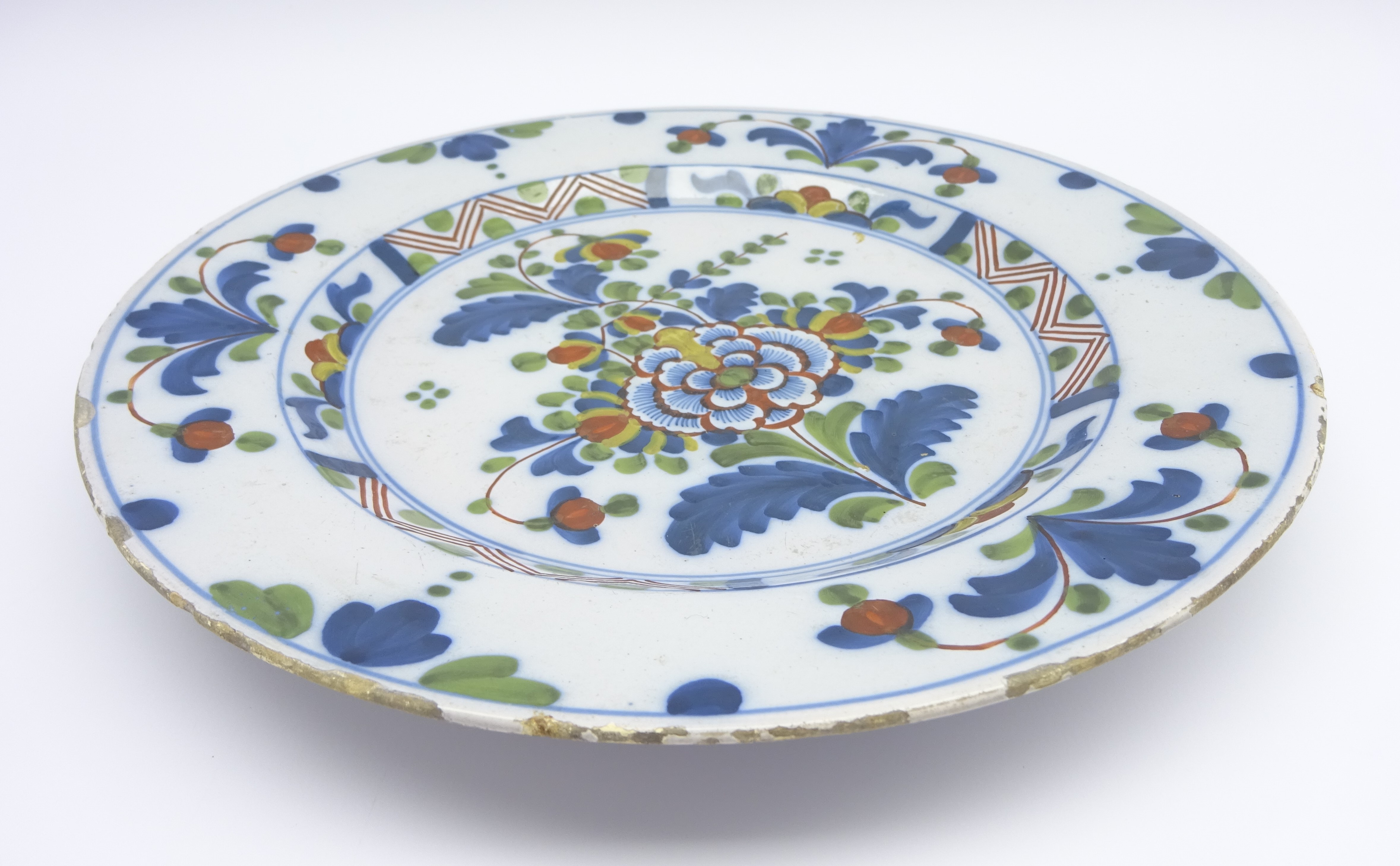 18th Century English Delft plate decorated with stylised flowers in blue, green and red, - Image 2 of 3