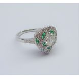 White gold heart shaped ring, central pear cut diamond with emerald and diamond surround,