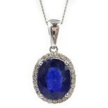 White gold oval sapphire and diamond pendant stamped 14K on 9ct white gold chain,