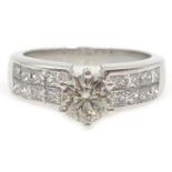 18ct white gold round brilliant cut diamond ring, with princess cut diamond shoulders, stamped 750,