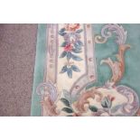 Large Chinese washed woollen rug carpet, pale mint ground, decorated with flowers and scrolls,