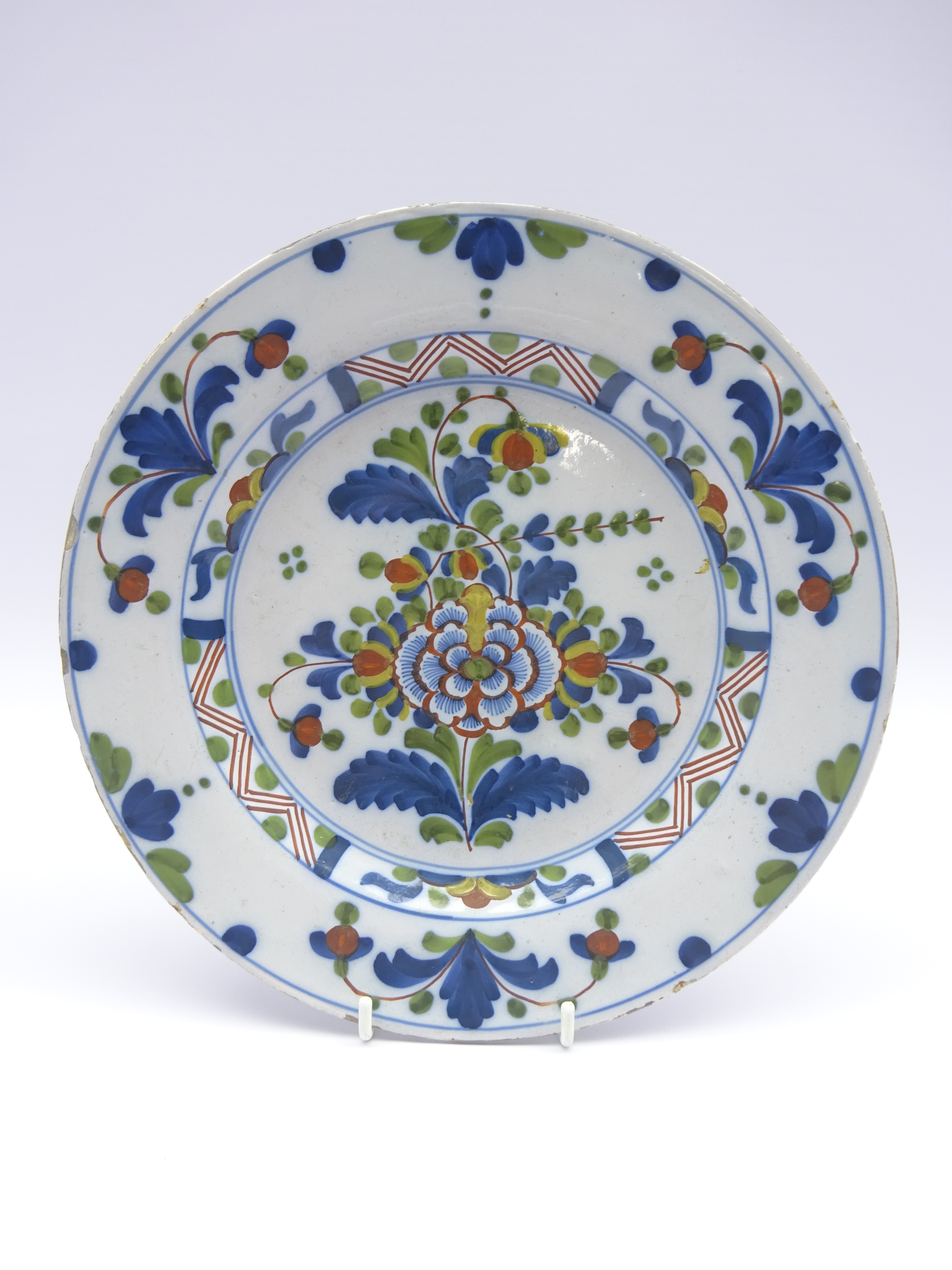 18th Century English Delft plate decorated with stylised flowers in blue, green and red,