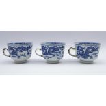 Three 18th century blue and white tea cups each decorated with Dragons amidst clouds,