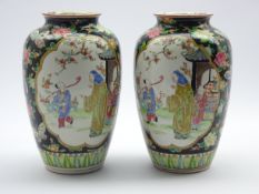 Pair of late 19th/ early 20th Century Oriental vases decorated with panels of figures surrounded by