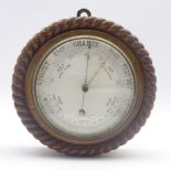 Late 19th century circular oak cased aneroid barometer in carved rope twist surround,