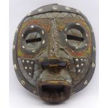 African carved hardwood mask with eyes, nose and mouth apertures, inlaid cowrie shells,