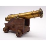 Bronze model of a cannon on oak carriage with turned mahogany wheels,