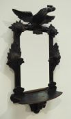Late 19th century wall mirror with shelf, ebonised frame carved with bird, flower heads and foliage,