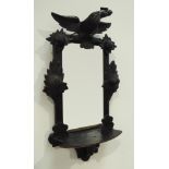 Late 19th century wall mirror with shelf, ebonised frame carved with bird, flower heads and foliage,