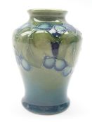 Small Moorcroft baluster shaped vase decorated in the 'Leaf & Berries' pattern on green ground,