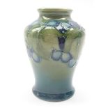 Small Moorcroft baluster shaped vase decorated in the 'Leaf & Berries' pattern on green ground,